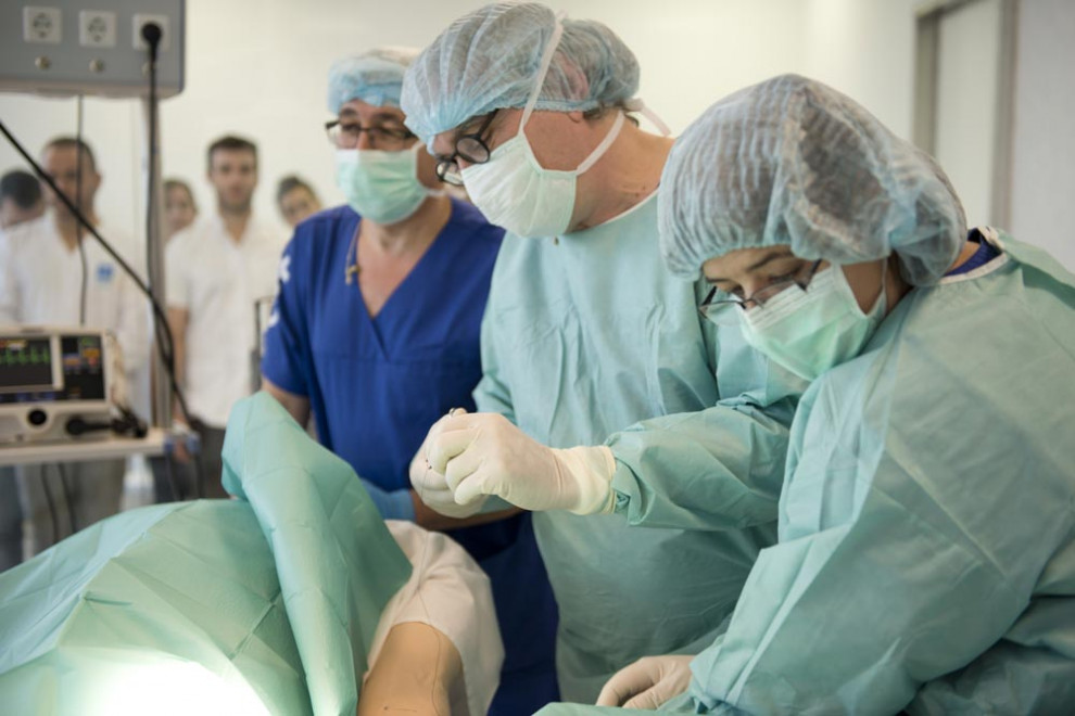 Sanitaris atenent un pacient simulat al quiròfan de la Clínica Universitària i el CISARC