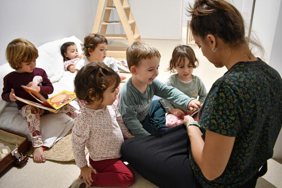 Una educadora amb infants a l'escola bressol Upetita