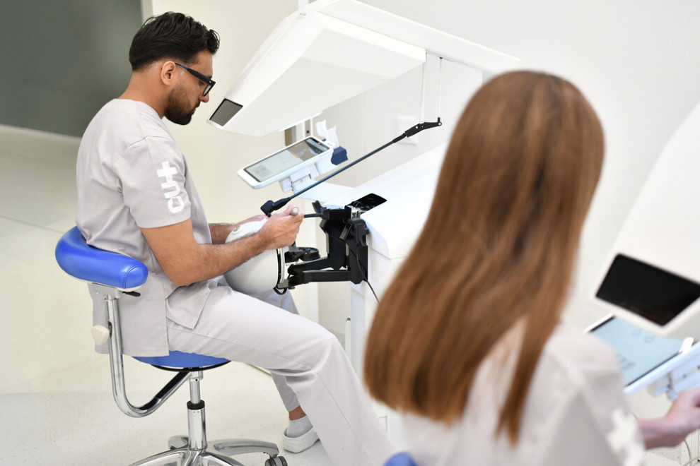 Estudiantat d'Odontologia practicant amb els simuladors hàptics