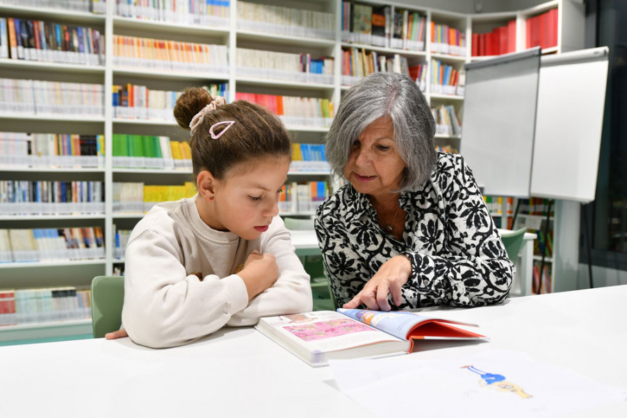Una voluntària del programa Lecxit amb una de les nenes lectores